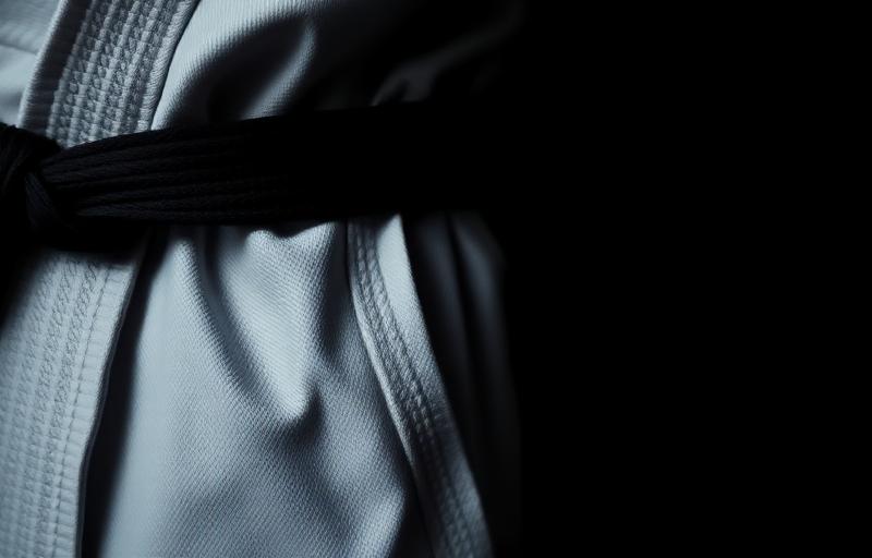 Detail of a white BJJ gi and black belt
